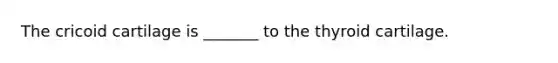 The cricoid cartilage is _______ to the thyroid cartilage.