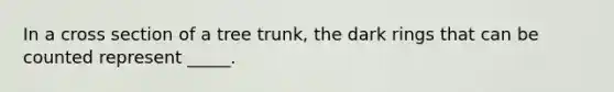 In a cross section of a tree trunk, the dark rings that can be counted represent _____.