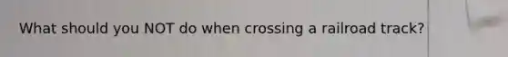 What should you NOT do when crossing a railroad track?