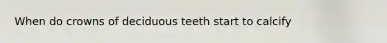 When do crowns of deciduous teeth start to calcify