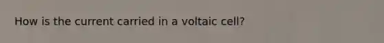 How is the current carried in a voltaic cell?