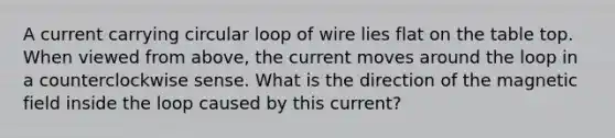 A current carrying circular loop of wire lies flat on the table top. When viewed from above, the current moves around the loop in a counterclockwise sense. What is the direction of the magnetic field inside the loop caused by this current?