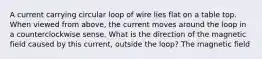 A current carrying circular loop of wire lies flat on a table top. When viewed from above, the current moves around the loop in a counterclockwise sense. What is the direction of the magnetic field caused by this current, outside the loop? The magnetic field