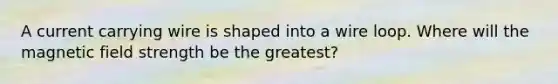 A current carrying wire is shaped into a wire loop. Where will the magnetic field strength be the greatest?