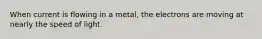 When current is flowing in a metal, the electrons are moving at nearly the speed of light.