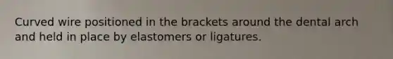 Curved wire positioned in the brackets around the dental arch and held in place by elastomers or ligatures.