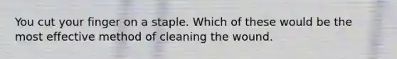 You cut your finger on a staple. Which of these would be the most effective method of cleaning the wound.