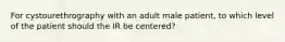 For cystourethrography with an adult male patient, to which level of the patient should the IR be centered?