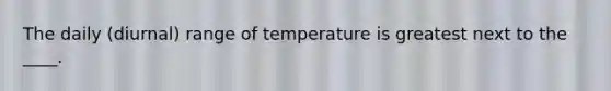 The daily (diurnal) range of temperature is greatest next to the ____.