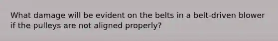 What damage will be evident on the belts in a belt-driven blower if the pulleys are not aligned properly?