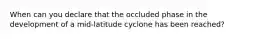 When can you declare that the occluded phase in the development of a mid-latitude cyclone has been reached?