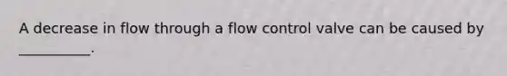 A decrease in flow through a flow control valve can be caused by __________.