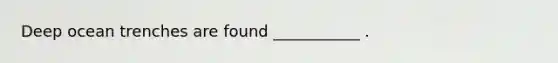 Deep ocean trenches are found ___________ .