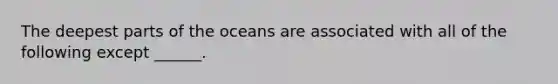 The deepest parts of the oceans are associated with all of the following except ______.