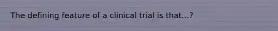 The defining feature of a clinical trial is that...?