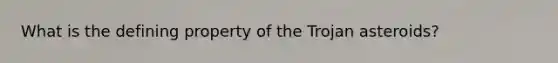 What is the defining property of the Trojan asteroids?