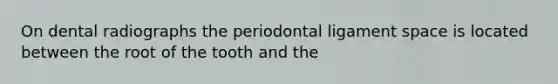 On dental radiographs the periodontal ligament space is located between the root of the tooth and the