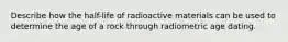 Describe how the half-life of radioactive materials can be used to determine the age of a rock through radiometric age dating.