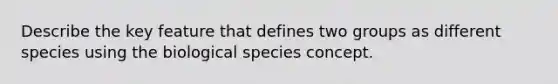 Describe the key feature that defines two groups as different species using the biological species concept.