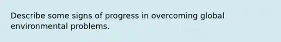 Describe some signs of progress in overcoming global environmental problems.