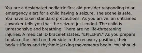 You are a designated pediatric first aid provider responding to an emergency alert for a child having a seizure. The scene is safe. You have taken standard precautions. As you arrive, an untrained coworker tells you that the seizure just ended. The child is unresponsive and breathing. There are no life-threatening injuries. A medical ID bracelet states, "EPILEPSY." As you prepare to place the child on their side in the recovery position, their body stiffens and rhythmic jerking movements begin. You should: