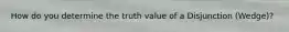 How do you determine the truth value of a Disjunction (Wedge)?