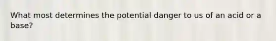 What most determines the potential danger to us of an acid or a base?