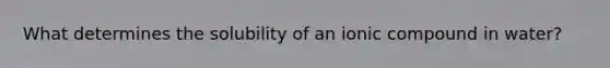 What determines the solubility of an ionic compound in water?