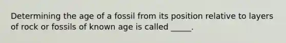 Determining the age of a fossil from its position relative to layers of rock or fossils of known age is called _____.