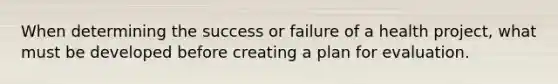 When determining the success or failure of a health project, what must be developed before creating a plan for evaluation.