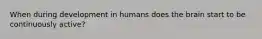 When during development in humans does the brain start to be continuously active?