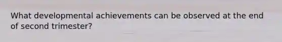 What developmental achievements can be observed at the end of second trimester?