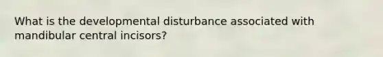 What is the developmental disturbance associated with mandibular central incisors?