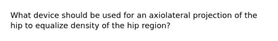 What device should be used for an axiolateral projection of the hip to equalize density of the hip region?