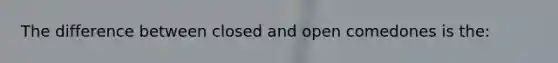 The difference between closed and open comedones is the: