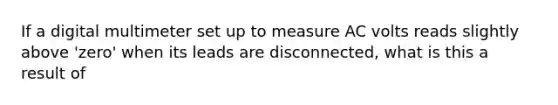 If a digital multimeter set up to measure AC volts reads slightly above 'zero' when its leads are disconnected, what is this a result of