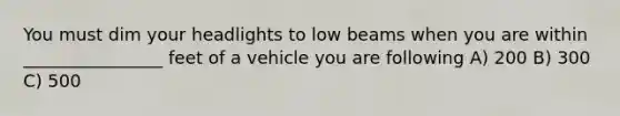 You must dim your headlights to low beams when you are within ________________ feet of a vehicle you are following A) 200 B) 300 C) 500