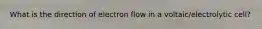 What is the direction of electron flow in a voltaic/electrolytic cell?