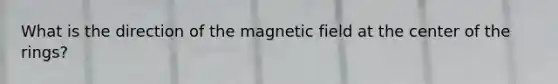 What is the direction of the magnetic field at the center of the rings?