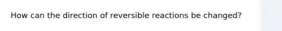 How can the direction of reversible reactions be changed?