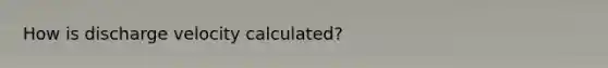 How is discharge velocity calculated?