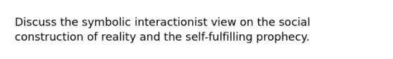 Discuss the symbolic interactionist view on the social construction of reality and the self-fulfilling prophecy.