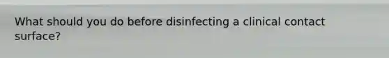 What should you do before disinfecting a clinical contact surface?