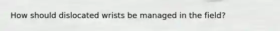 How should dislocated wrists be managed in the field?