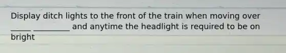 Display ditch lights to the front of the train when moving over _____ _________ and anytime the headlight is required to be on bright