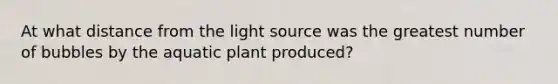 At what distance from the light source was the greatest number of bubbles by the aquatic plant produced?