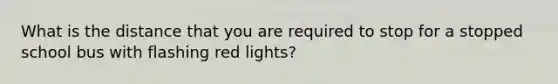 What is the distance that you are required to stop for a stopped school bus with flashing red lights?