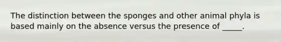 The distinction between the sponges and other animal phyla is based mainly on the absence versus the presence of _____.