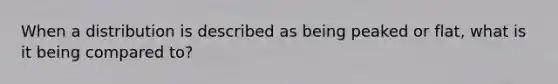 When a distribution is described as being peaked or flat, what is it being compared to?