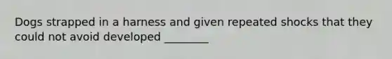 Dogs strapped in a harness and given repeated shocks that they could not avoid developed ________